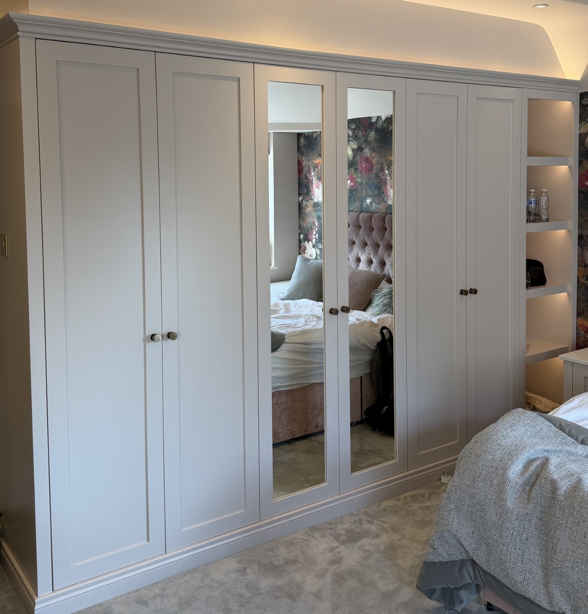 Bespoke panelled wardrobes with mirrored doors and illuminated shelving